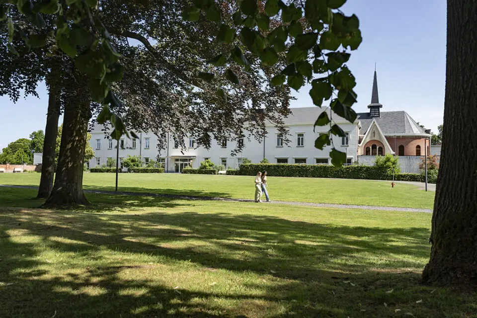 Twee mensen wandelen over het terrein van campus Alexianen