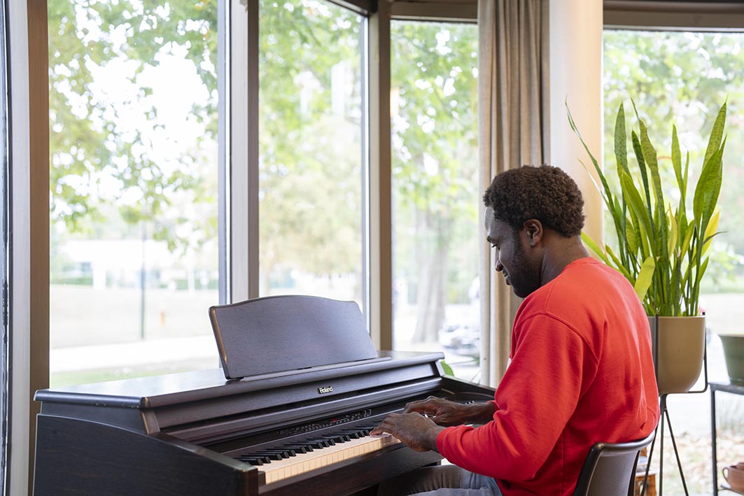 Cliënt speelt piano op een afdeling